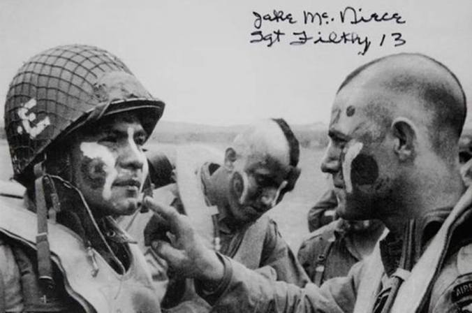 U.S. Soldiers, including Jake McNiece, right, assigned to the 101st Airborne Division apply war paint to each other's face in England June 5, 1944, in preparation for the invasion of Normandy, France, the next day. The morning of June 6, 1944, Allied forces conducted a massive airborne assault and amphibious landing in the Normandy region of France. The invasion marked the beginning of the final phase of World War II in Europe, which ended with the surrender of Germany the following May. McNiece led a demolition group called the Filthy 13, whose exploits were credited with the inspiration of the film 